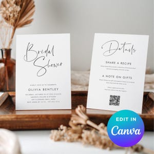 Könnte beinhalten: Zwei weiße Brautparty-Einladungskarten mit schwarzem Text. Die erste Karte sagt "Bridal Shower" in Kursivschrift, mit Veranstaltungsdetails unten. Die zweite Karte sagt "Details" und enthält einen QR-Code. Die Karten liegen auf einem Holztablett.