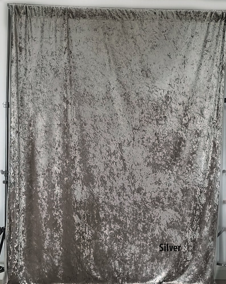May include: A silver crushed velvet backdrop for photography. The backdrop is textured and has a subtle shimmer. The word "Silver" is printed in black at the bottom right corner.