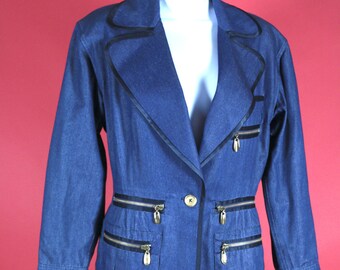 May include: A denim suit, featuring a blazer and skirt, displayed on a mannequin. The blazer has black trim, gold zippers, and a single button closure. The skirt is a matching denim material.