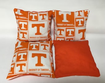 May include: Set of six orange and white bean bags with the University of Tennessee logo and the words "University of Tennessee" repeated on each bag.