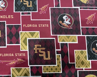 May include: A red, black, and gold fabric with a repeating pattern of the Florida State Seminoles logo, the words "Florida State", and a spear.