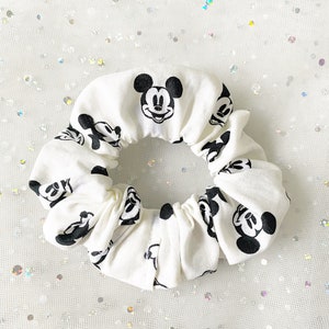 Puede incluir: Scrunchie blanco con estampado de Mickey Mouse en blanco y negro.