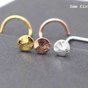 Puede incluir: Tres piercings de nariz con tapas circulares texturizadas de 3 mm en oro, oro rosa y plata. El texto "3mm Circle" es visible. Los pendientes tienen un poste curvo para la inserción.