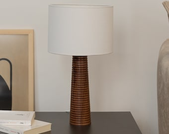 Artisanat intemporel : lampe de table faite main en bois de noyer avec une forme conique élégante et des anneaux intrigants