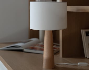 Resplandor natural: lámpara de mesa hecha a mano de madera de haya con una sofisticada base en forma de cono, que infunde calidez y estilo en su espacio