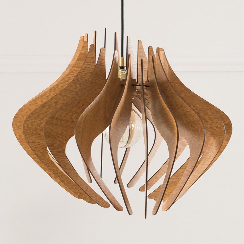 May include: A pendant light fixture featuring a series of curved, light brown wooden slats arranged in a circular, open-frame design. The structure hangs from a black cord with a brass-colored socket holding a single clear glass light bulb.