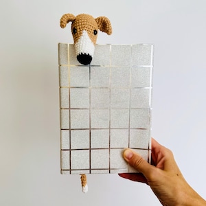 May include: A crocheted brown and white dog bookmark with a silver glitter covered notebook.