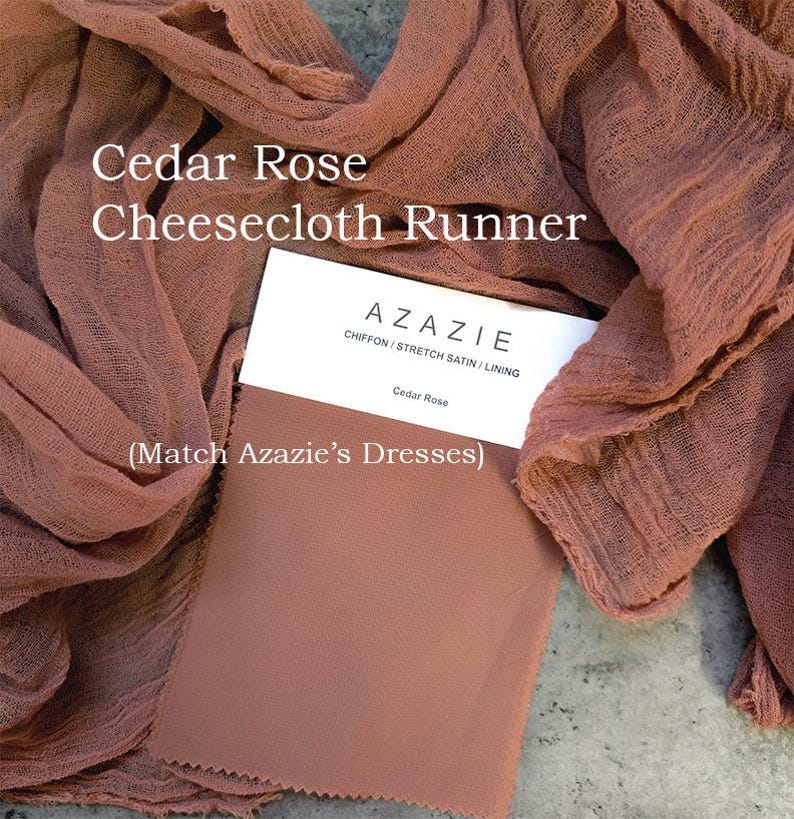 May include: A rust-colored cheesecloth runner with the text "Cedar Rose Cheesecloth Runner" and "AZAZIE CHIFFON/STRETCH SATIN/LINING Cedar Rose (Match Azazie's Dresses)" printed on a white tag.