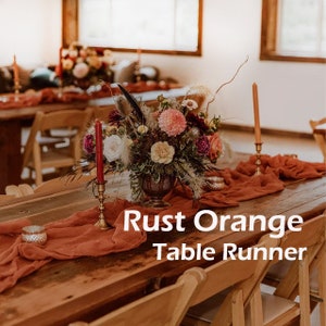 May include: A rustic wooden table with a rust orange table runner, a floral centerpiece, and two candlesticks. The text "Rust Orange Table Runner" is superimposed on the image.