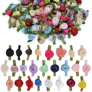 Peut inclure: Une collection de petites roses en ruban de tissu de diverses couleurs, dont rouge, rose, bleu, jaune, blanc et violet. Chaque rose présente une petite tige en ruban vert attachée à la base, disposée en tas et en rangées organisées.