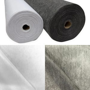 May include: Two rolls of fabric are displayed, one in solid white and one in a heathered charcoal grey. The fabric has a textured, non-woven appearance. Below, close-up views show the white fabric surface and the grey fabric surface.