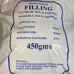 May include: A white plastic bag containing 450gms of multi-purpose filling. The text reads: MULTI-PURPOSE FILLING, SYNTHETIC NON ALLERGENIC, WASHABLE AND FLAREPROOF, COMPLIES TO: CLEANLINESS BS1425, SUITABLE FOR: BS5665, EUROPEAN STANDARD EN71, 450gms, WARNING: TO AVOID THE DANGERS OF SUFFOCATION PLEASE KEEP THIS BAG AWAY FROM BABIES AND CHILDREN.