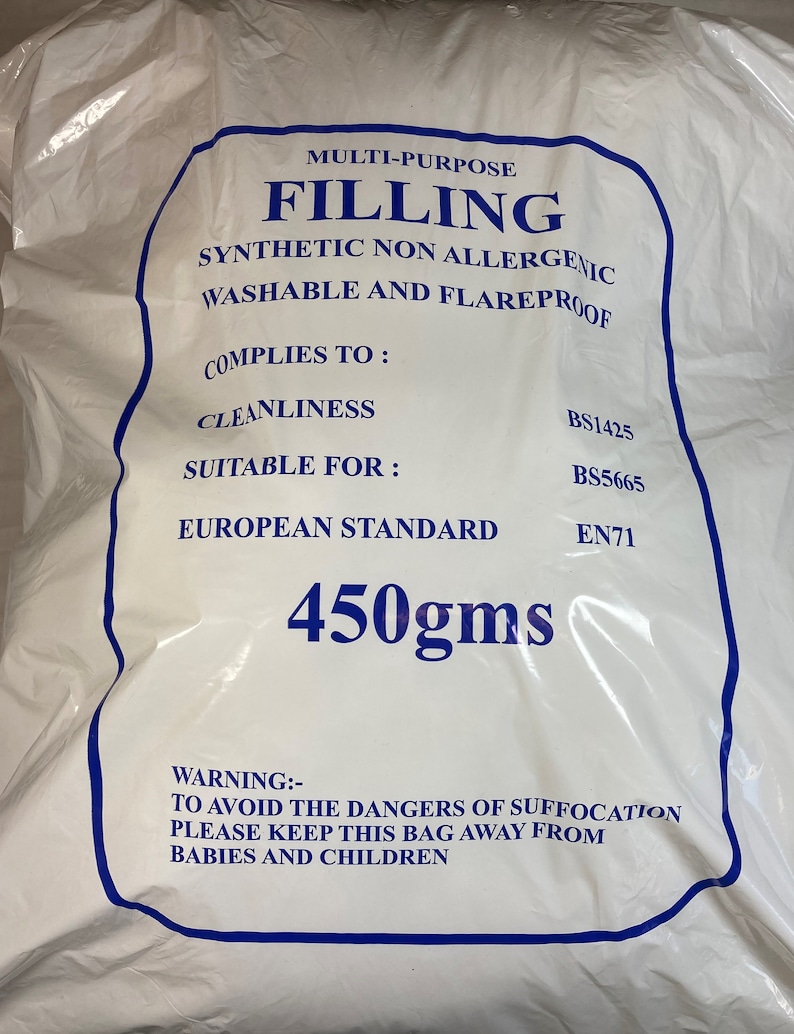 May include: A white plastic bag containing 450gms of multi-purpose filling. The text reads: MULTI-PURPOSE FILLING, SYNTHETIC NON ALLERGENIC, WASHABLE AND FLAREPROOF, COMPLIES TO: CLEANLINESS BS1425, SUITABLE FOR: BS5665, EUROPEAN STANDARD EN71, 450gms, WARNING: TO AVOID THE DANGERS OF SUFFOCATION PLEASE KEEP THIS BAG AWAY FROM BABIES AND CHILDREN.