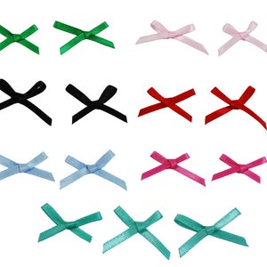 May include: An assortment of small satin ribbon bows in various colours, including green, black, light blue, red, pink, and teal. The bows are arranged in rows of three, with each row featuring a different colour.