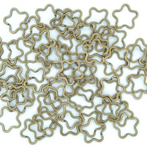 May include: A pile of gold-toned metal star-shaped key rings.