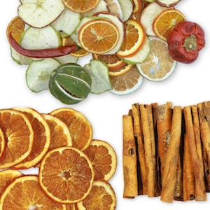 May include: A collection of dried fruit and spices, including orange slices, apple slices, cinnamon sticks, and a red pepper. The fruit and spices are arranged on a white background.