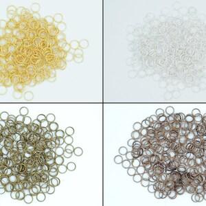May include: A collection of four piles of jump rings in different finishes: gold, silver, bronze, and antique brass. The jump rings are small and circular, ideal for jewellery making.