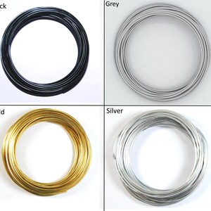 May include: Four spools of wire in different colors: black, gray, gold, and silver. The wire is coiled into a circle.