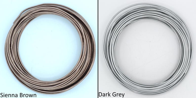 May include: Two spools of wire, one in sienna brown and one in dark grey. The wire is coiled neatly.