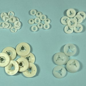 May include: Assortment of white plastic caps with three prongs. The caps are in various sizes and shapes.