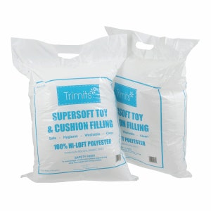 May include: Two white plastic bags containing Trimits supersoft toy and cushion filling made of 100% hi-loft polyester. The bags feature blue text detailing that the filling is safe, hygienic, washable, and clean, with safety warnings included.
