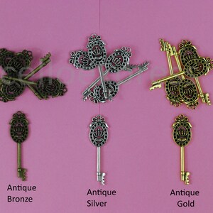 Peut inclure: Trois ensembles de clés anciennes avec des détails de couronne. Les clés sont en bronze antique, argent et or.