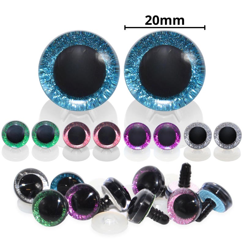 May include: A collection of craft eyes in various colors, including blue, green, pink, purple, and silver. The largest pair of eyes are 20mm in diameter. Each eye has a black pupil and a glittery, reflective iris. Some eyes have screw-in posts.