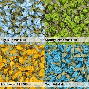 May include: Assortment of small, fabric rose embellishments in four colors: sky blue, spring green, sunflower yellow, and teal. Each rose has a green stem and is approximately 1 inch in diameter.