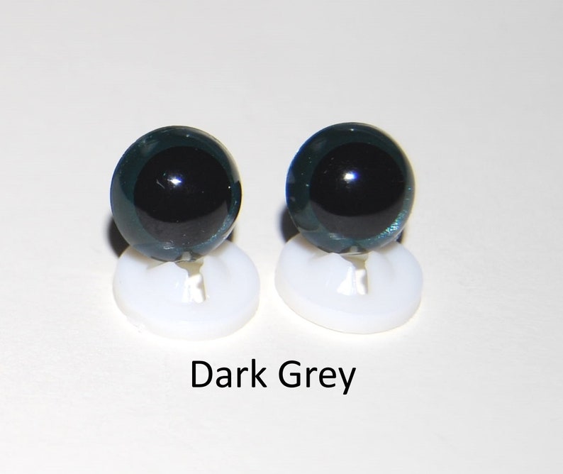 May include: Two dark grey plastic safety eyes with black pupils, mounted on white plastic bases.  Dark Grey.