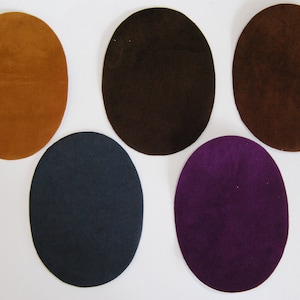 May include: Five oval-shaped suede patches in different colours: brown, dark brown, navy blue, purple, and a lighter brown. The patches are all the same size and shape.