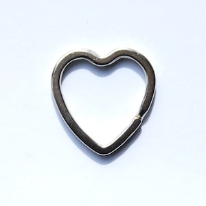 May include: A silver heart-shaped key ring.