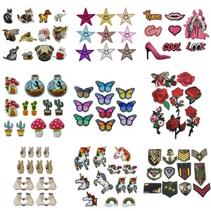 May include: A collection of colourful iron-on patches featuring various designs, including animals, stars, flowers, butterflies, unicorns, peace signs, hearts, and military insignia.