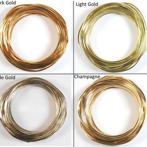 May include: Four spools of gold wire in different shades: dark gold, light gold, pale gold, and champagne.