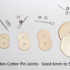 May include: A selection of wooden cotter pin joints, ranging from 6mm to 55mm, accompanied by metal cotter pins and washers. The wooden components are circular with a central aperture. Suitable for crafts.