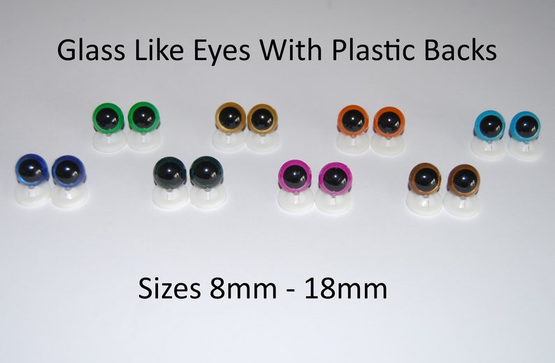 May include: Assortment of glass-like plastic eyes in various colors, including green, gold, orange, blue, dark blue, black, pink, and brown. The eyes are 8mm to 18mm in size and have plastic backs.