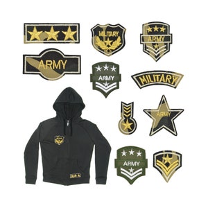 May include: A black hooded sweatshirt with a zip and a small camouflage patch on the front. The sweatshirt is surrounded by various embroidered patches with military themes, including "Army", "Military", and stars.