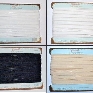 Peut inclure: Quatre bobines d'élastique antidérapant de 10 mètres en blanc, noir, beige et nude. Les bobines sont étiquetées "Nortexx Non Slip Elastic".
