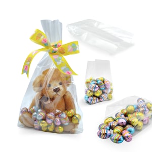 May include: Clear cellophane bags with a yellow ribbon and Easter-themed print. The bags contain a small teddy bear and chocolate Easter eggs.
