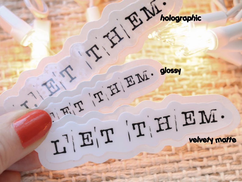 a hand holding a pair of white stickers