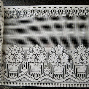 May include: White lace valance with a floral design. The valance features a repeating pattern of flower pots with flowers.