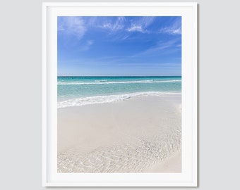 May include: A white sandy beach with turquoise water and a blue sky with white clouds.