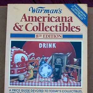 May include: A vintage book titled "Warman's Americana & Collectibles, 8th Edition." The cover features a collage of antique items, including a Coca-Cola sign and various collectibles. The book is a price guide for antiques.