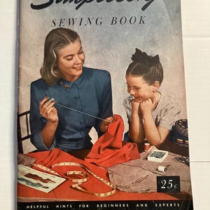 May include: Vintage "Simplicity Sewing Book" cover featuring a woman and a girl sewing. The cover has the title in black script, with the words "SEWING BOOK" below. The cover also includes the text "HELPFUL HINTS FOR BEGINNERS AND EXPERTS" and a price of 25¢.