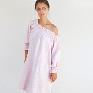 May include: A pink off-the-shoulder linen dress with ruffled sleeves. The dress is knee-length and has a relaxed fit.