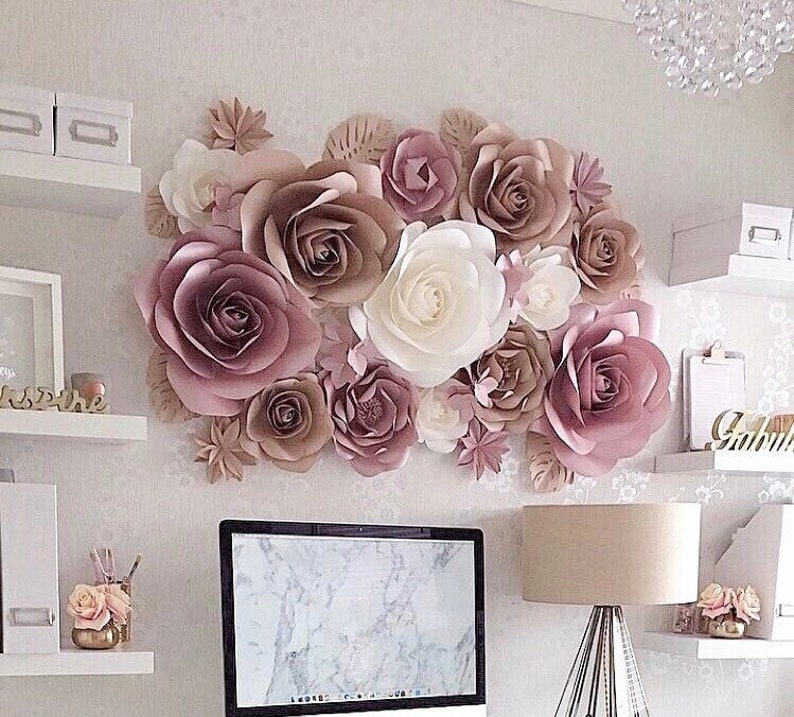 K&ouml;nnte beinhalten: Eine Wand, die mit gro&szlig;en Papierblumen in Rosat&ouml;nen, Braun und Wei&szlig; dekoriert ist. Die Blumen sind in einer Gruppe angeordnet und schaffen ein wundersch&ouml;nes und elegantes Dekor.