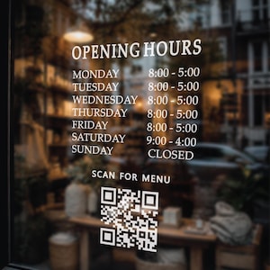 May include: A glass storefront displays business hours in white text: Monday to Friday 8:00 AM to 5:00 PM, Saturday 9:00 AM to 4:00 PM, and Sunday closed. A QR code is also visible, with the text "SCAN FOR MENU".