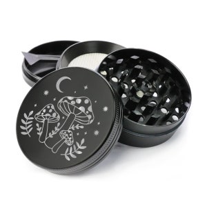 May include: Black metal grinder with a mushroom and moon design. The grinder has a three-piece design with a screen and a herb catcher.
