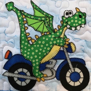 May include: A green dragon with yellow spots and wings rides a blue motorcycle with black wheels. The dragon has a toothy grin and big eyes.