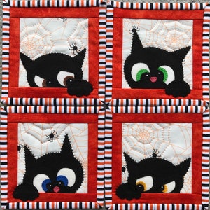 May include: Four black cat coasters with orange and white striped borders. Each coaster features a black cat peeking out from behind a white background with a spider web design.