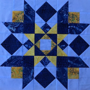 May include: A quilt block with a star design in yellow and blue fabrics. The star is surrounded by a border of blue and white squares.